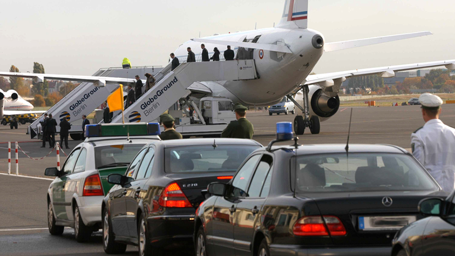 Staatsbesuch, hier gepanzerte Autos auf dem Rollfeld vor einem Flugzeug
